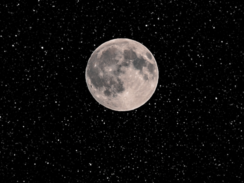 Ein großer runder Mond in der Mitte und im Hintergrund ein schwarzer Himmel voller Sterne 