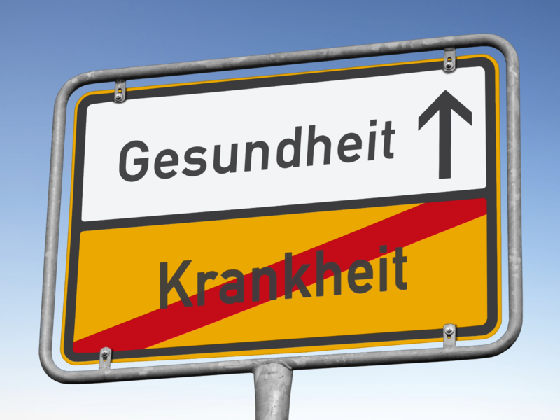 Ein Straßenschild mit der Aufschrift "Gesundheit" mit einem Pfeil nach oben und "Krankheit" durchgestrichen.