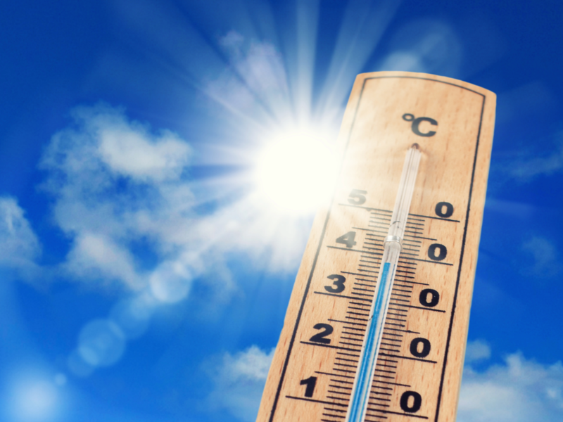 Ein Thermometer welches die Außentemperatur misst und im Hintergrund scheint die Sonne 